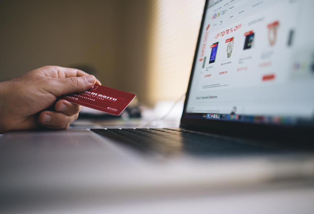 Person holding card while online shopping