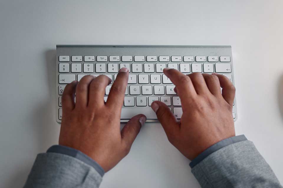 hands typing on a keyboard