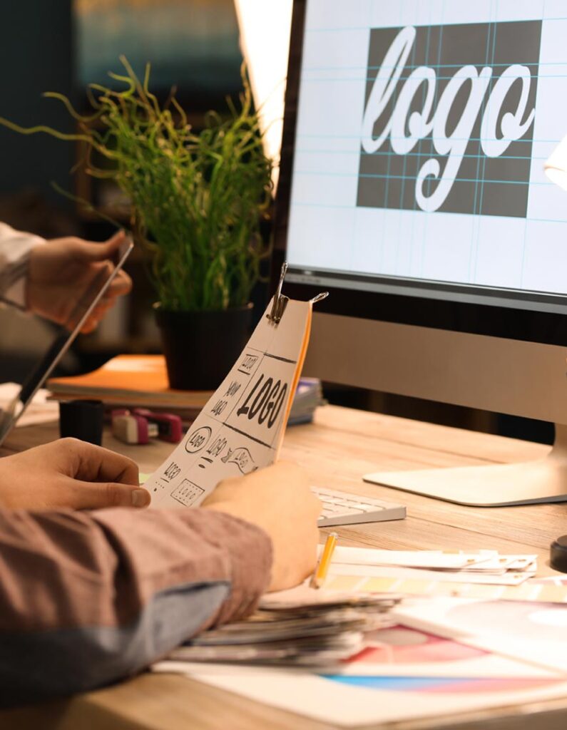 logodesign-1 logo graphic on screen, and person holding paper copy