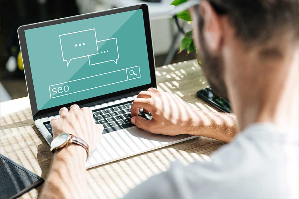 man types on a laptop at a desk